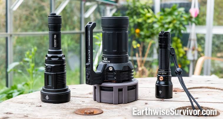 Three powerful flashlights standing on a wooden table