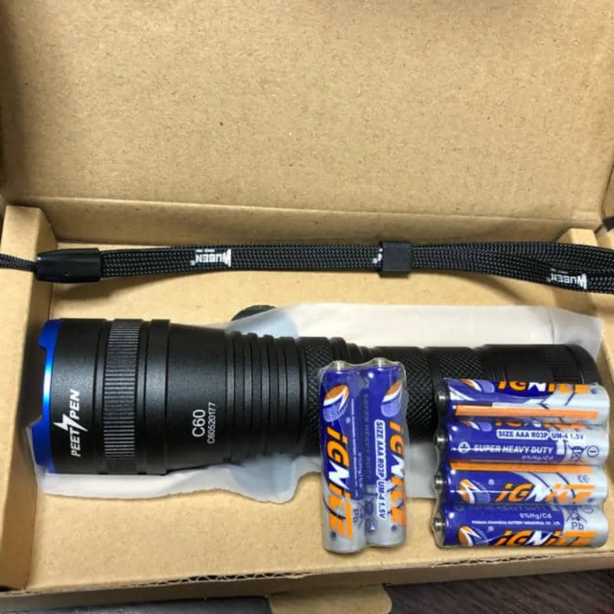 PEETPEN C60 LED flashlight in hand for night hikes, delivering 1000 Lumens zoomable beam in dark trails.